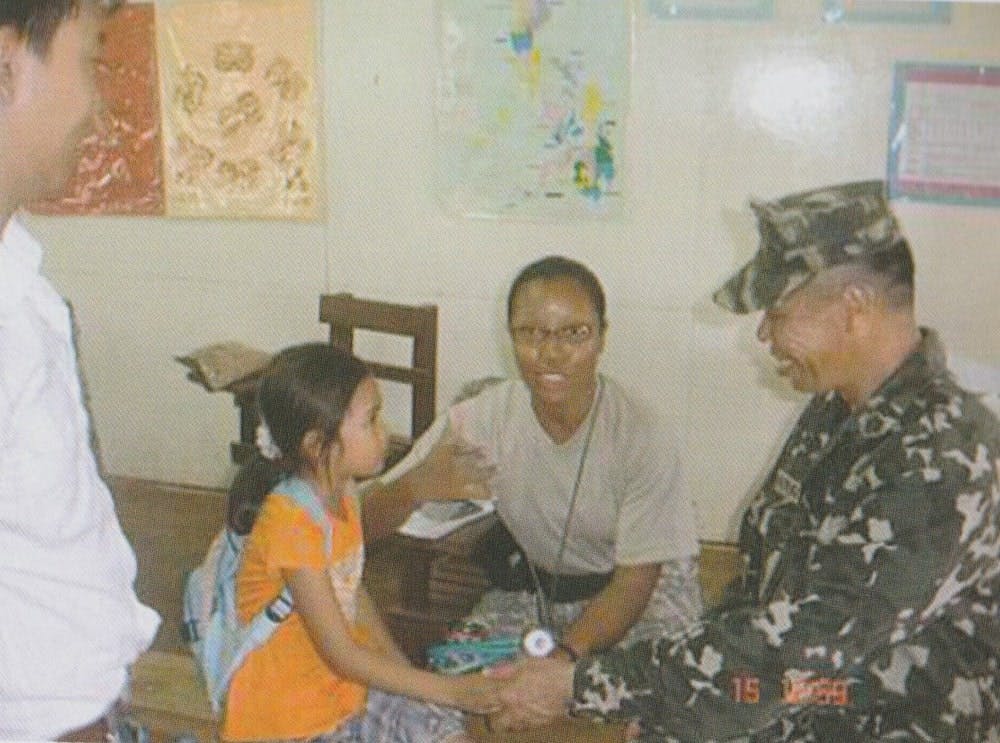 A Marine acts as a child's interpreter as a member of the US medical team checks the kid's health condition suring a MEDCAP activity in Tipo-Tipo Basilan