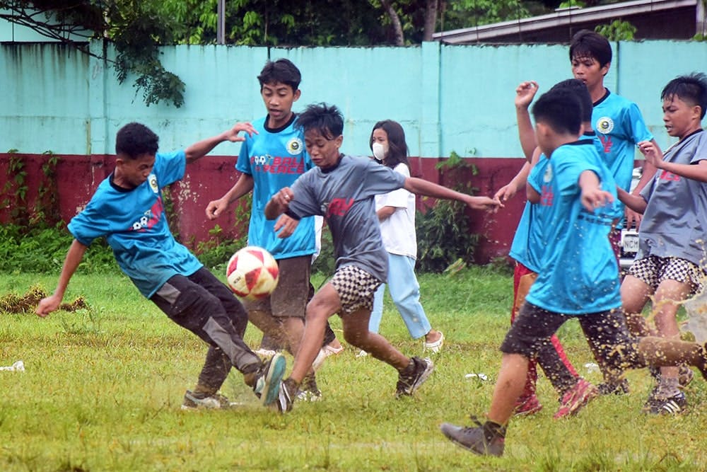 A grade schooler kicks the ball during the Football for Peace Festival
