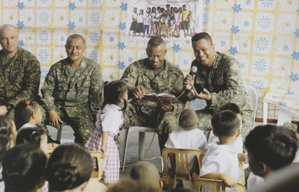 Members of the PMC and USMC conduct a storytelling activity during the execution of PHIBLEX Exercises