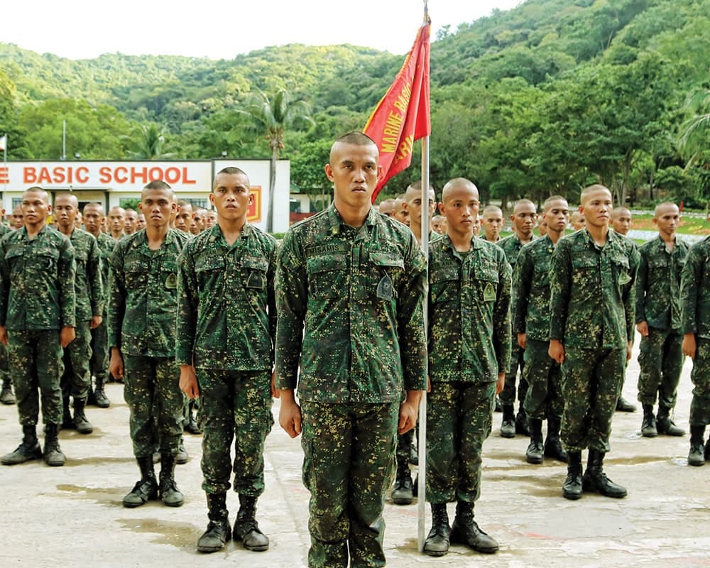 Marine Corps Reservists standing at attention alongside with their Marine Basic Class Flag